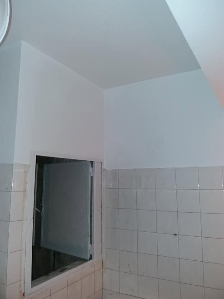 Το μπάνιο με λευκούς τοίχους πάνω από τα πλακάκια