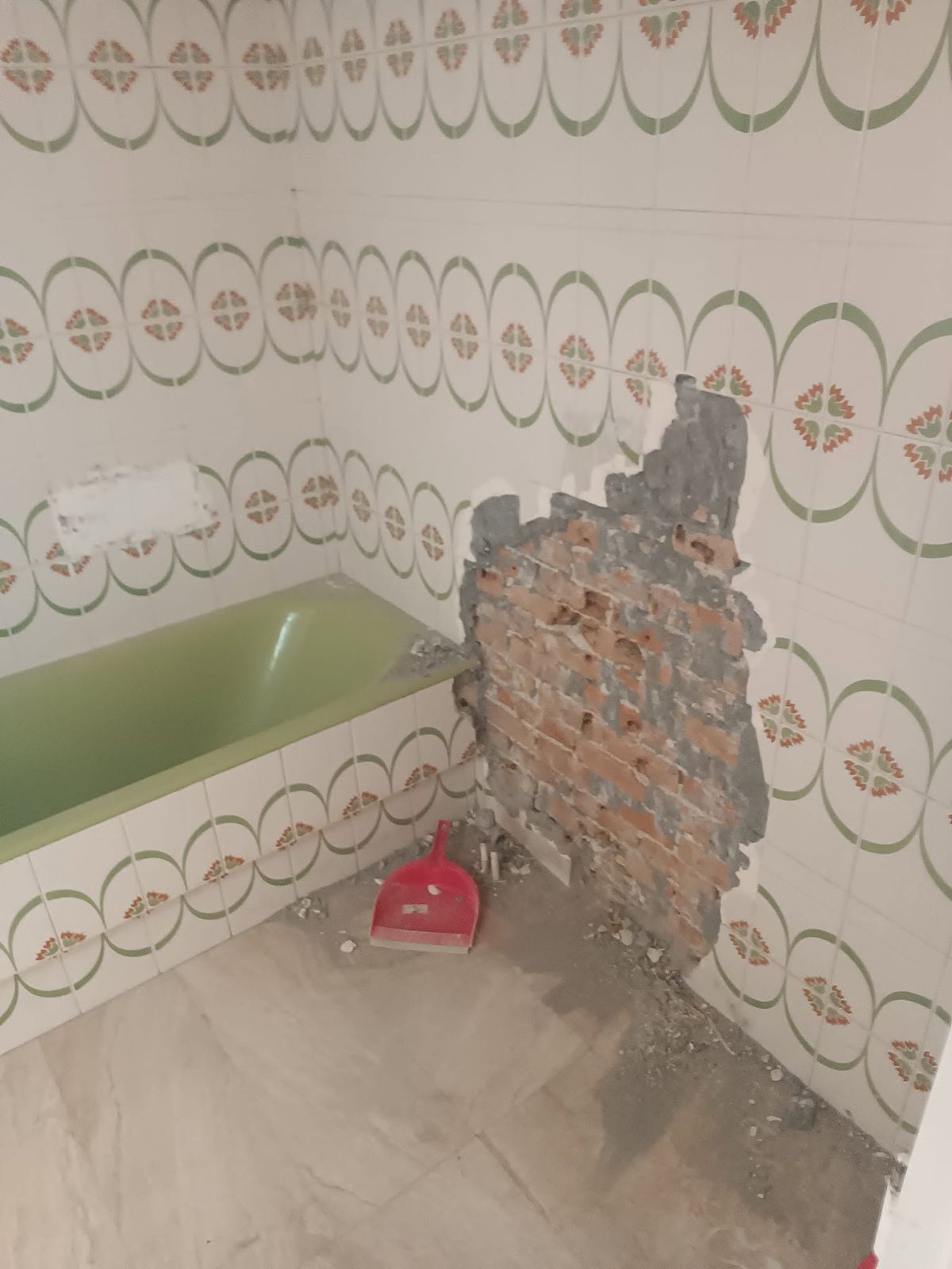 بلاط يُنزع عن الجدار فيظهر الطوب، بجانب الحوض الأخضر