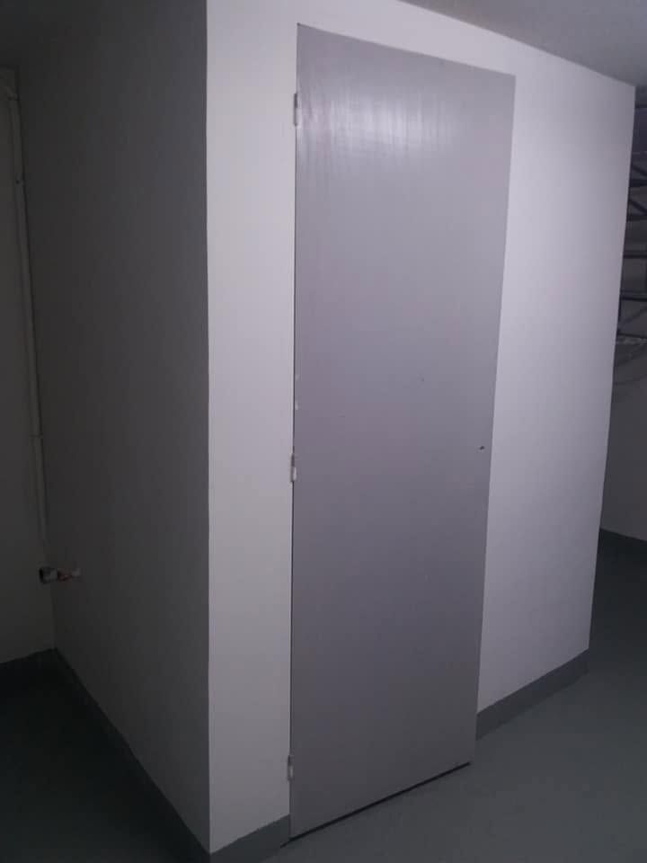 A toilet door painted soft grey