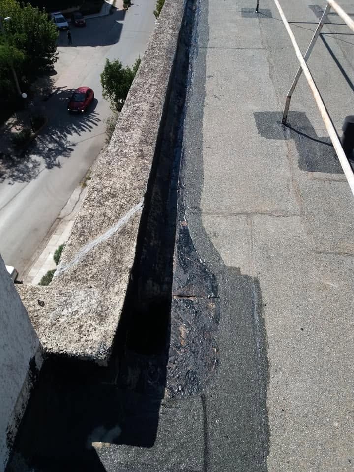 Dark primer in the corner between the roof and the parapet