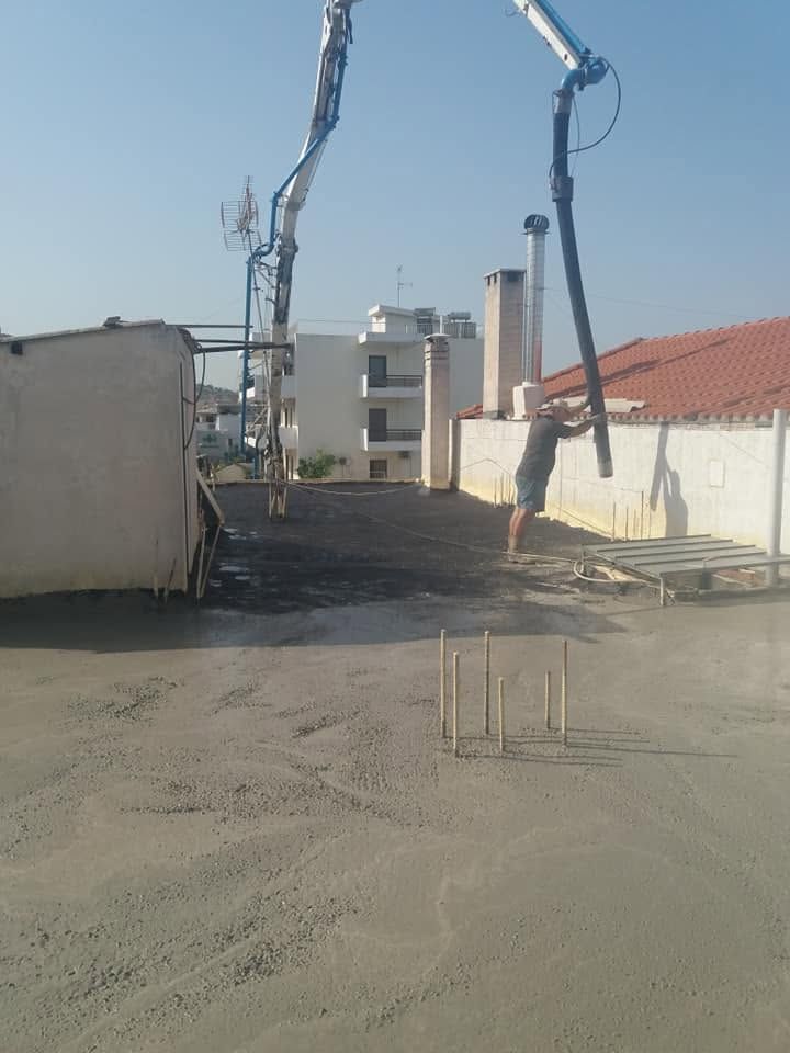 A pump hose pouring screed onto the roof