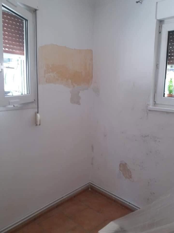بقعة وأضرار على الجدار بين نافذتين