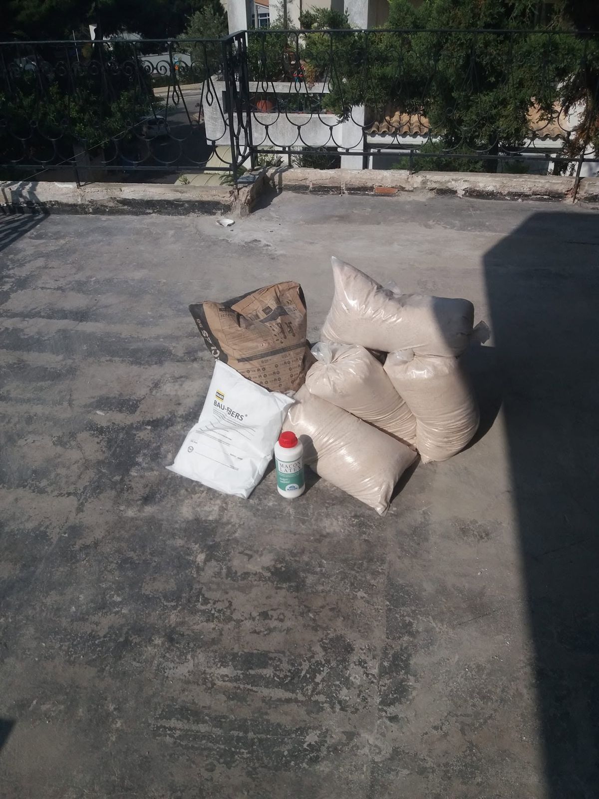 Σακιά με υλικό σε σκόνη και ένα μπουκάλι υγρού στην ταράτσα